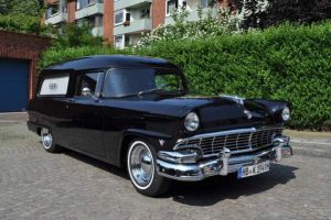Foto von einem schwarzen klassischen Bestattungswagen. Das Modell ist ein Oldtimer Ford Mainline.